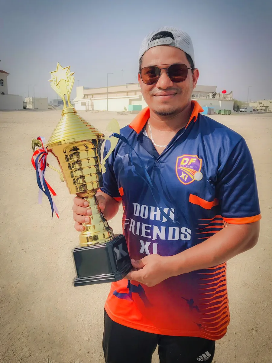Habib holding a trophy in a Doha Friends XI jersey