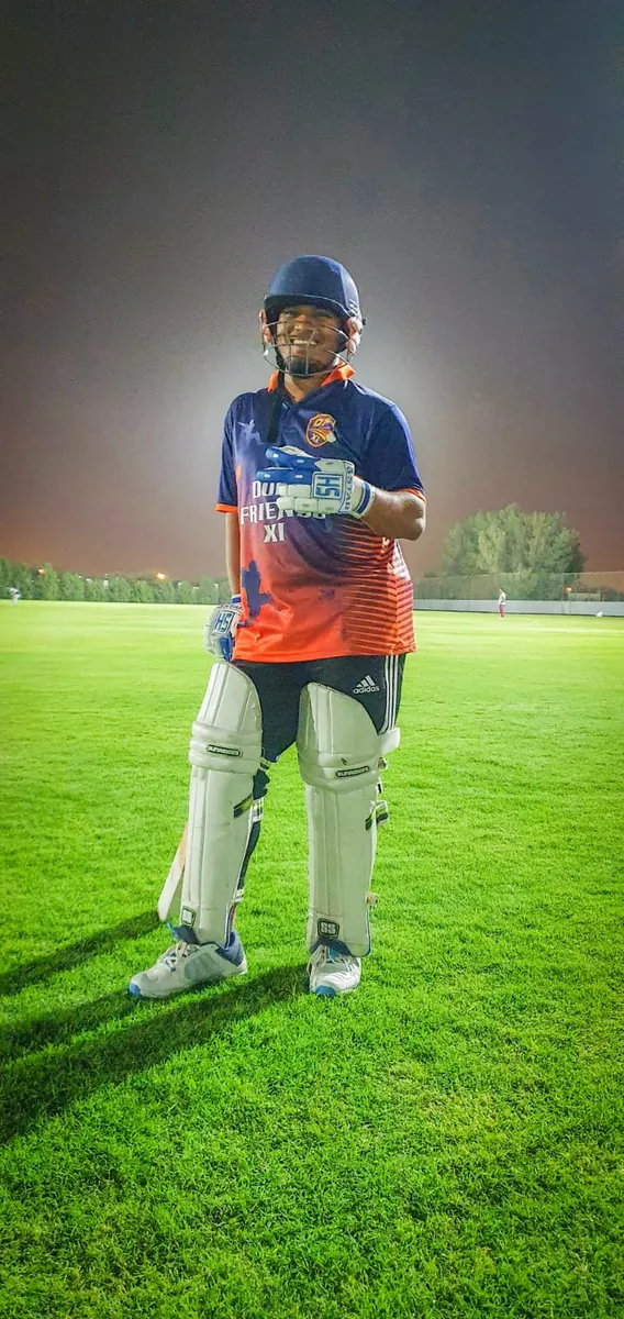 Habib in full batting gear on a green cricket field