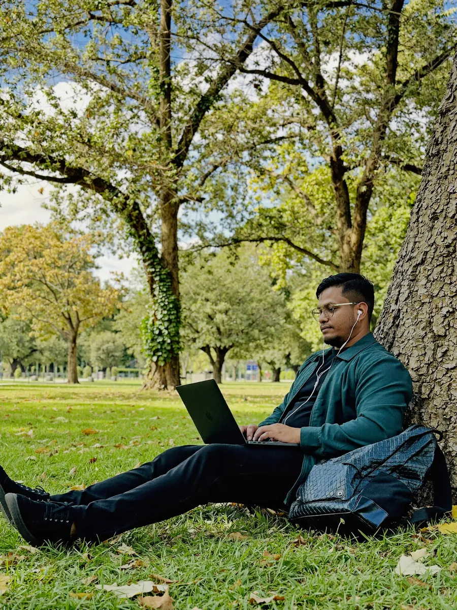 AI-generated image of Habib working on a laptop under a tree